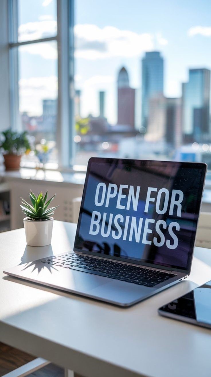Laptop screen displaying "Open For Business" text with city skyline background