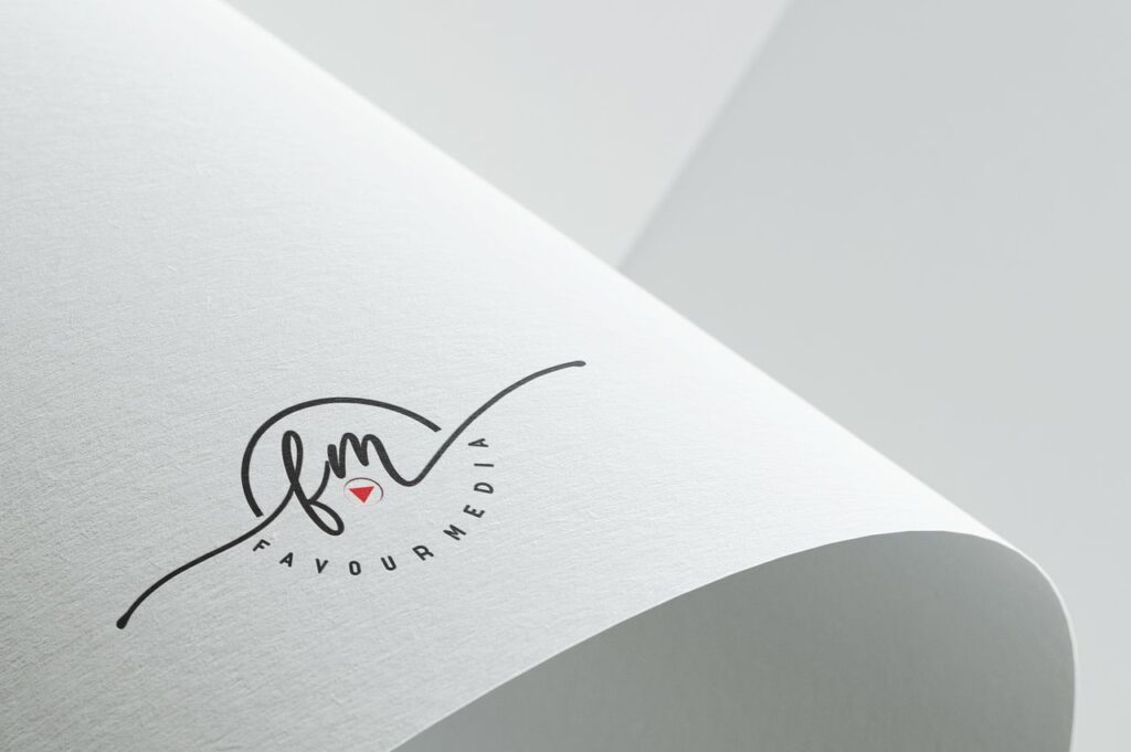 Minimalist design showcasing Favour Media logo on folded textured paper with copyspace.